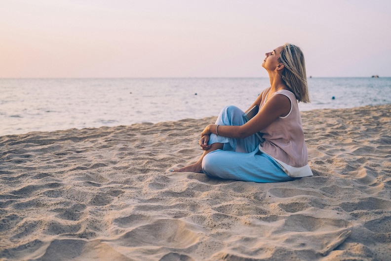 emotional grounding. woman sitting on beach to ground emotions